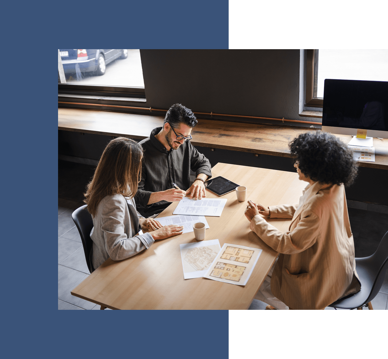 People meeting around a table with documents.