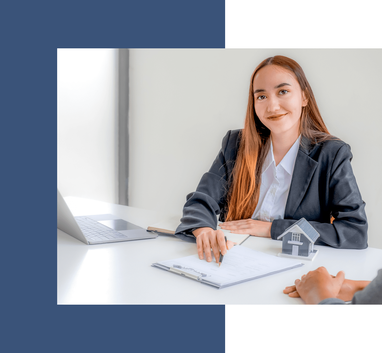 Businesswoman smiling during meeting, holding paperwork.